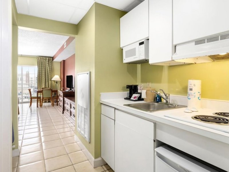 a kitchen with white cabinets and yellow walls