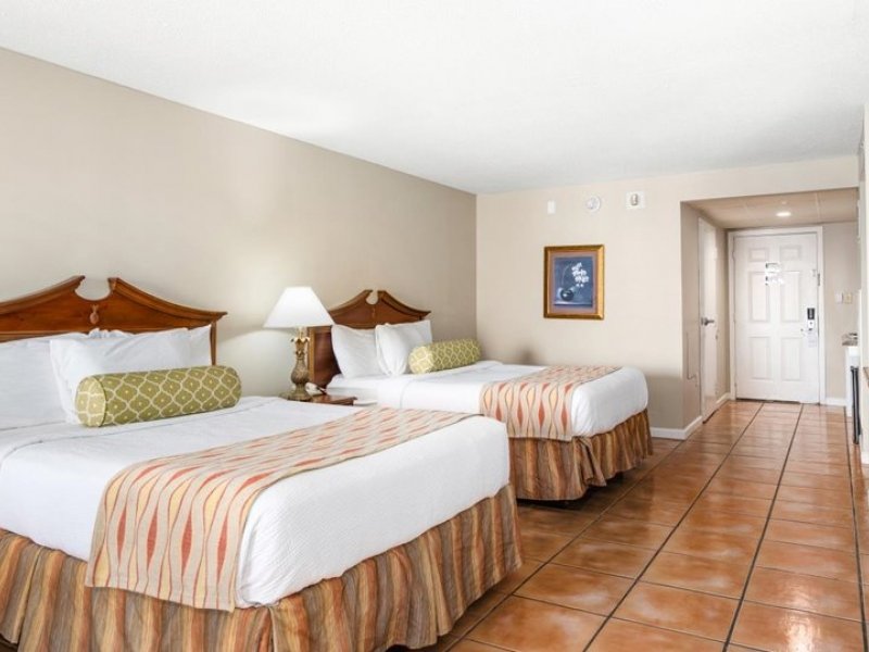 two beds in a hotel room with tiled floors