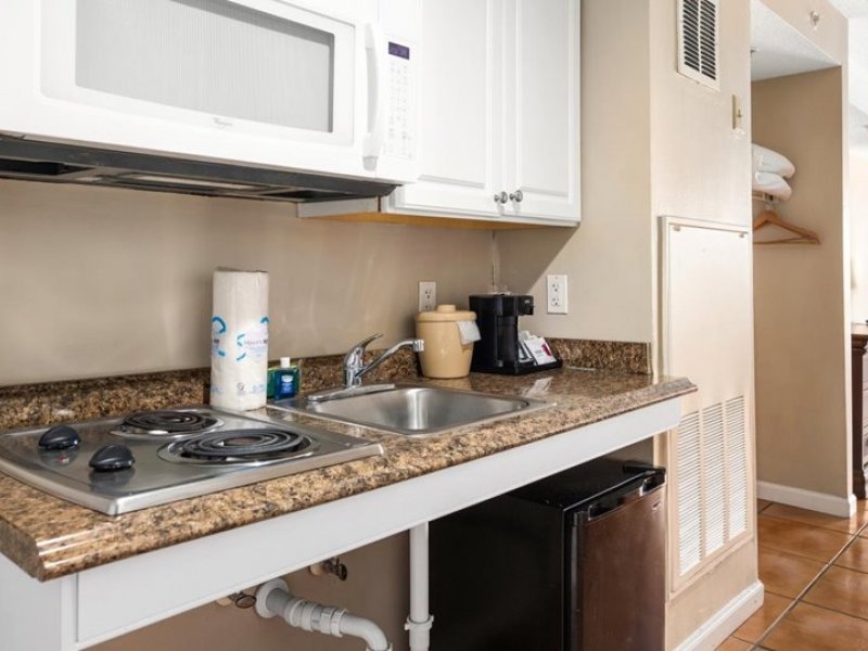 a kitchen with a stove top oven next to a microwave