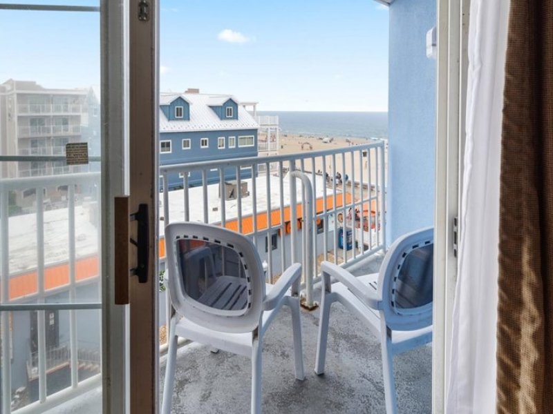 a balcony with two chairs facing the ocean