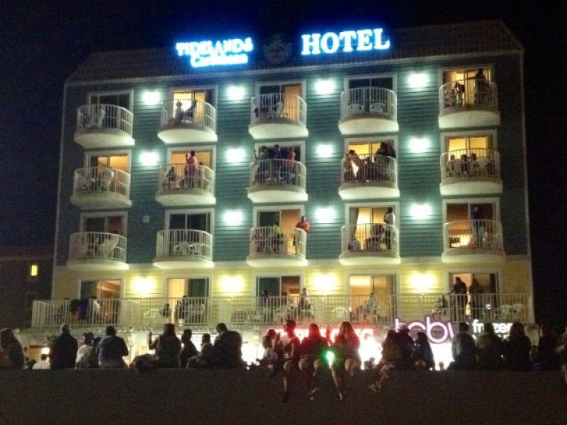 people are standing outside of a hotel at night