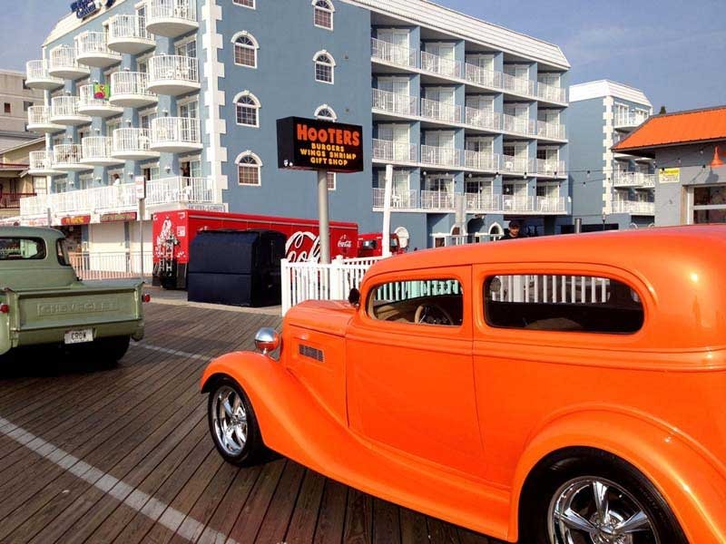 an orange car parked in front of a hotel